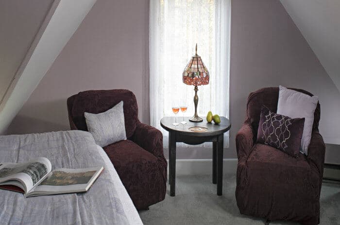 sitting area with two chairs flanking a small table and lamp