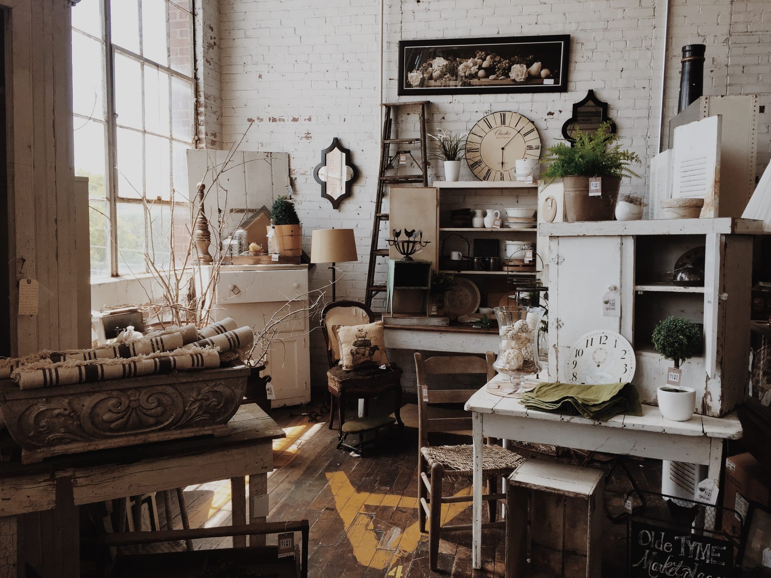 A vintage-style interior filled with eclectic decor items, including shelves, plants, and furniture.