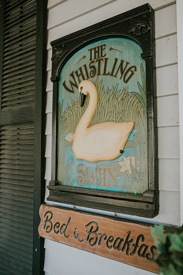 Sign for "The Whistling Swan Bed & Breakfast" featuring a painted swan and lily pads.