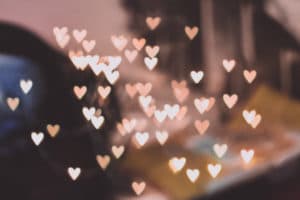 A blurred background with scattered heart-shaped bokeh lights.