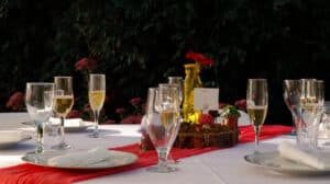 An elegantly set dining table with glasses and plates, adorned with a floral centerpiece.