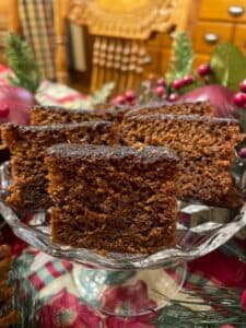 A close-up of sliced gingerbread cake displayed on a decorative glass plate.