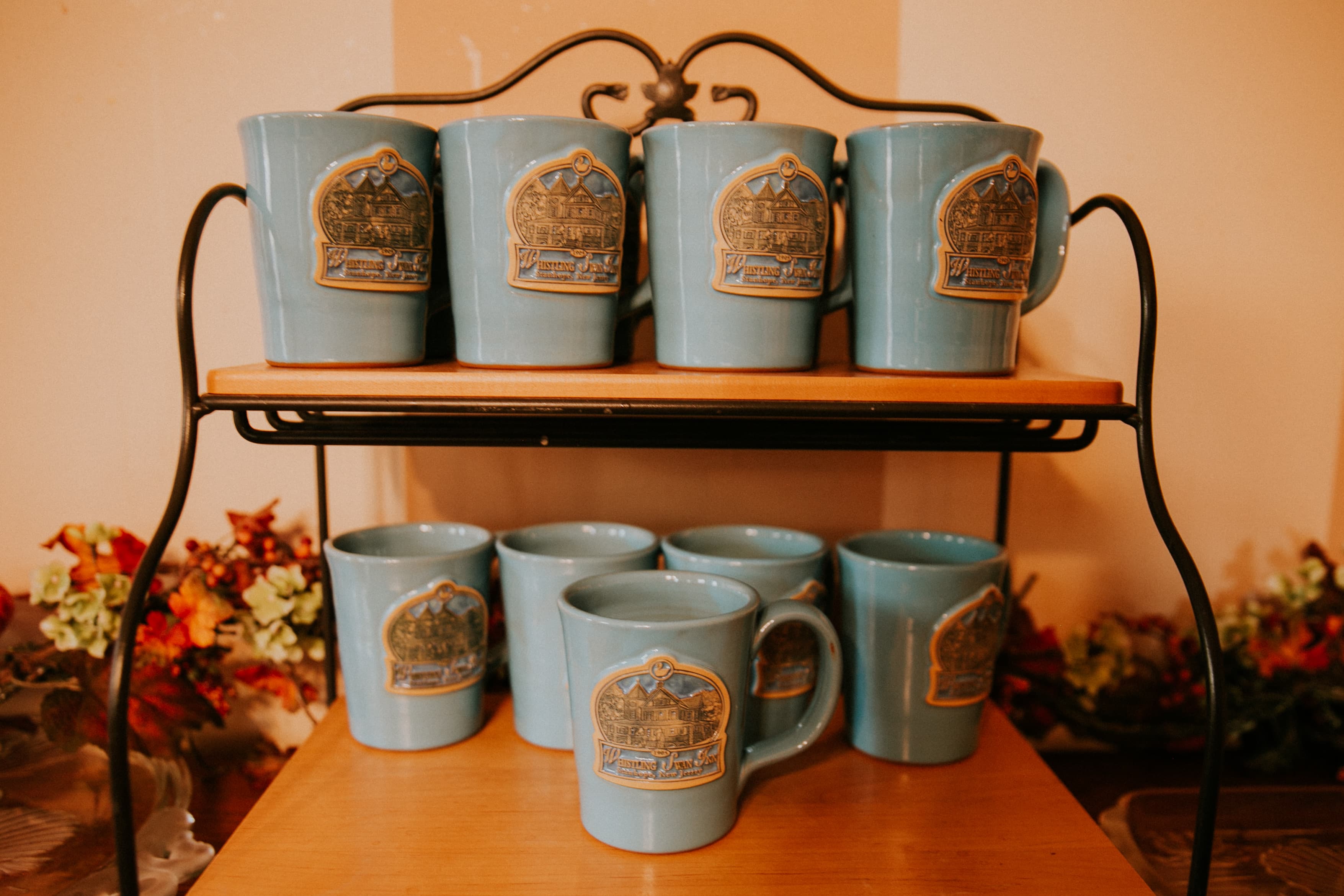 A display of blue cups with decorative logos on a wooden shelf.
