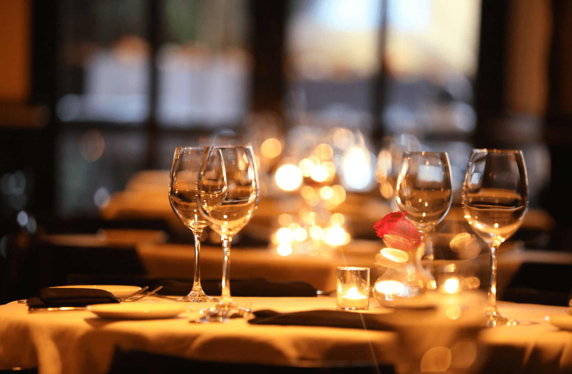 Fine dining restaurant table setting with wine goblets and dishes