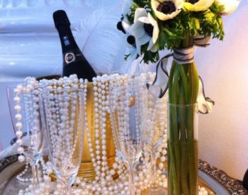Champagne bottle in ice bucket and vase of flowers