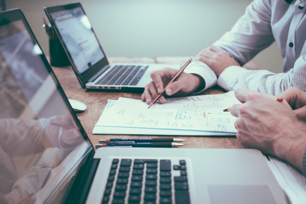 business meeting at a table with laptops and notepads