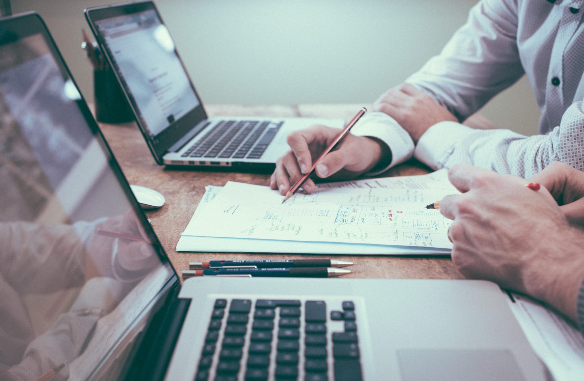 business meeting at a table with laptops and notepads