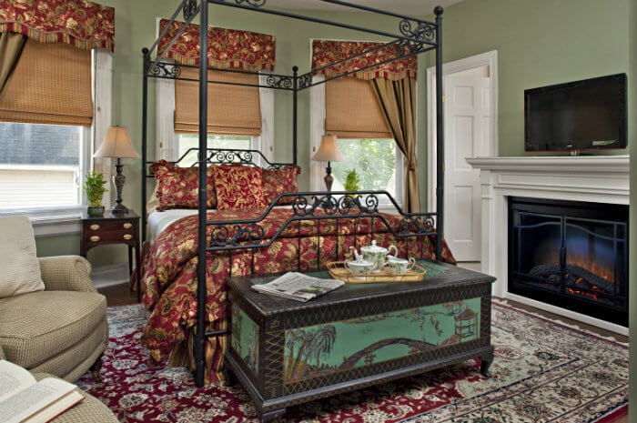 Large iron bed with red and yellow bedding