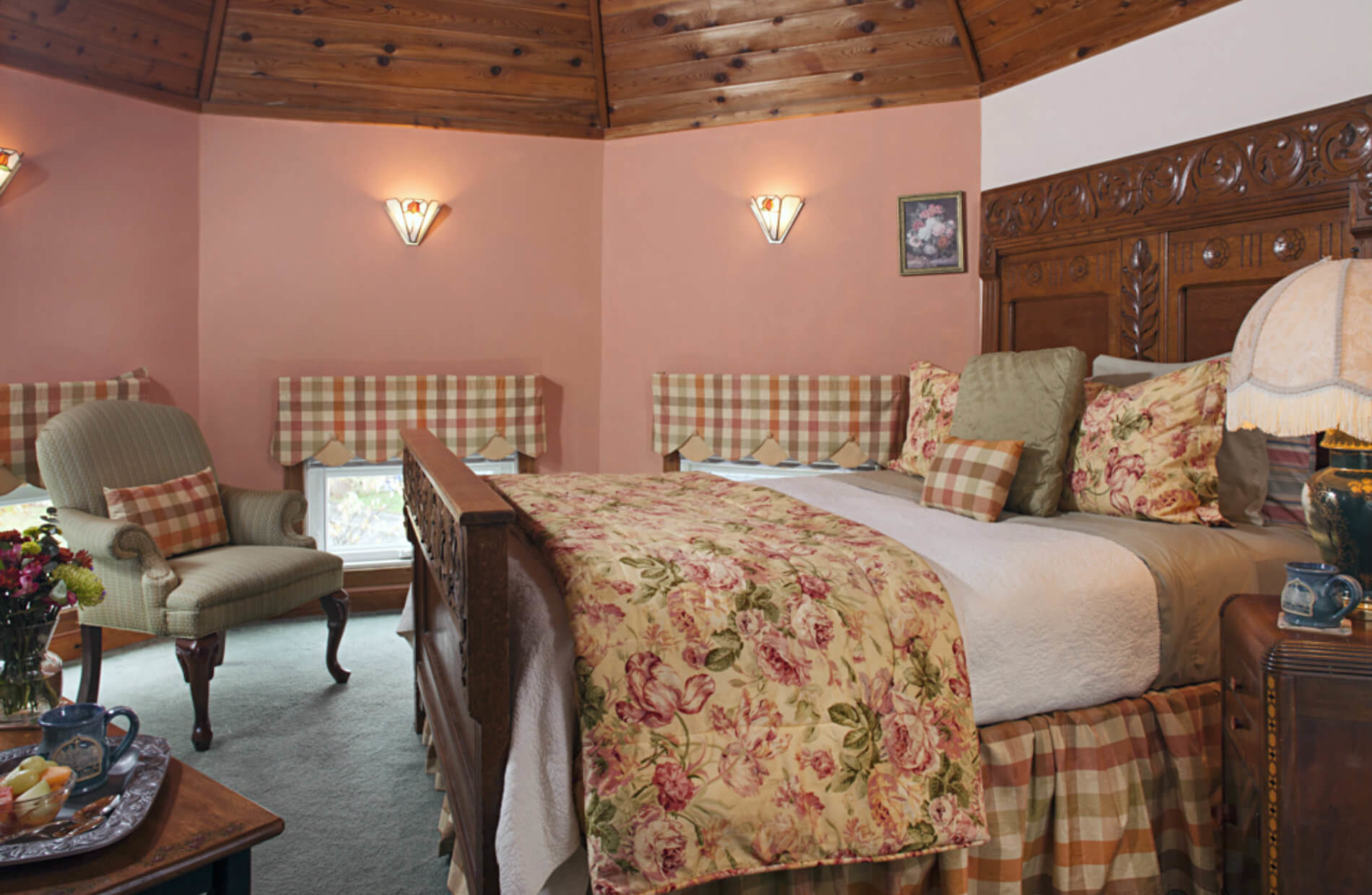 Peach walled room with wooden bed with soft flowered bedding