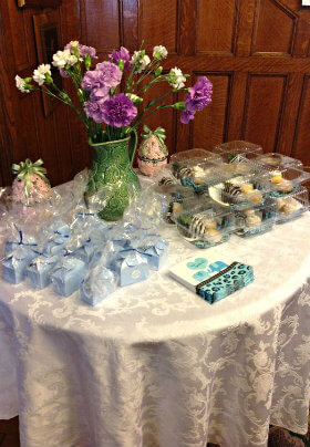 Round table with white damask cloth and flowers and party favors
