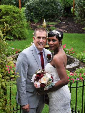 Bridal couple standing in front of garden