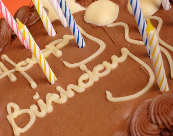 Chocolate Birthday cake with pink, blue and yellow candles