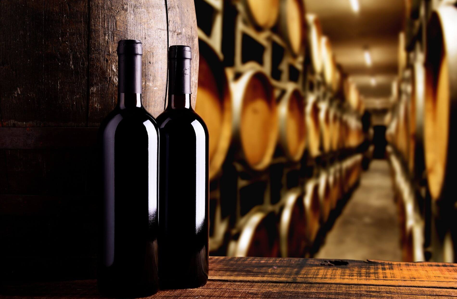 Wine bottles and barrels in a winery.